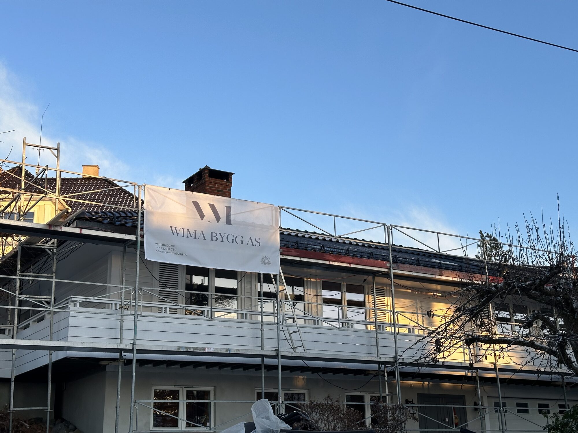 Midttunveien 8 – Arbeid på eksisterende bolig, med stillas og Wima-banner på fasaden.