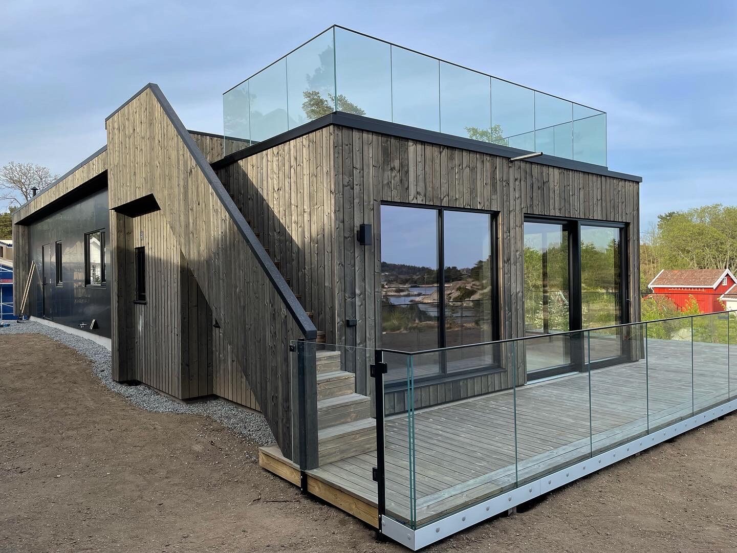 Stølekilen – Bygg med stående trekledning, glassrekkverk og store vindusflater.