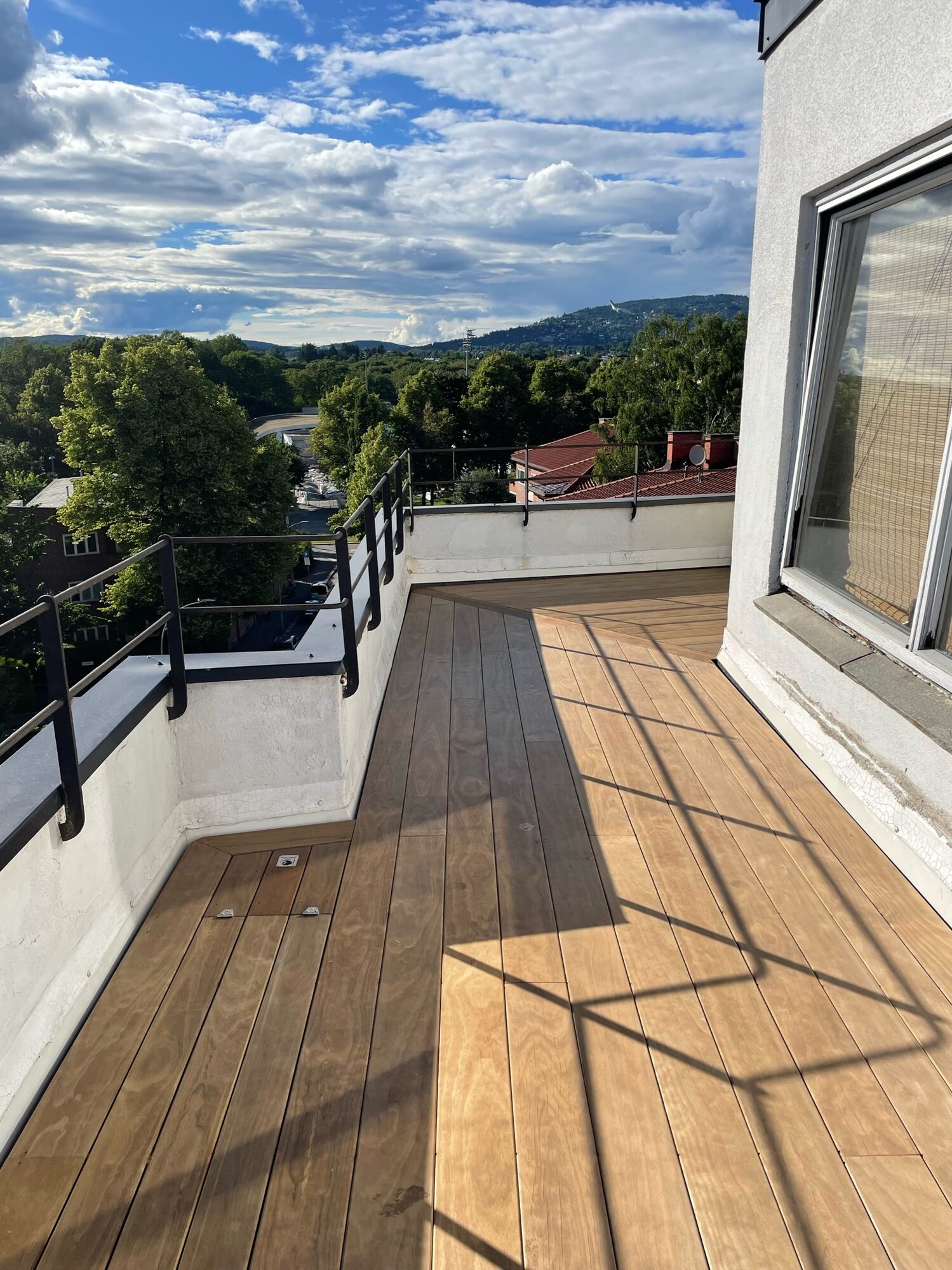 Jacob Aalls gate 1 – Takterrasse med terrassebord i tre og utsikt over byen.